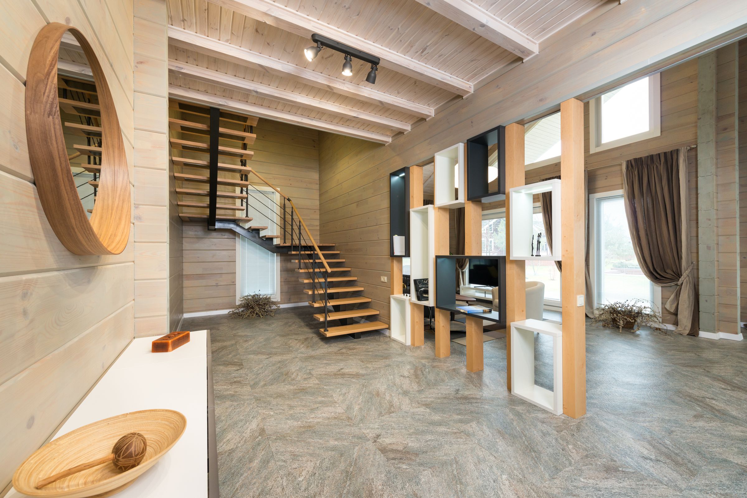 Bright residential hallway with wood staircase, console table and open shelving cabinets near Banchory, Royal Deeside