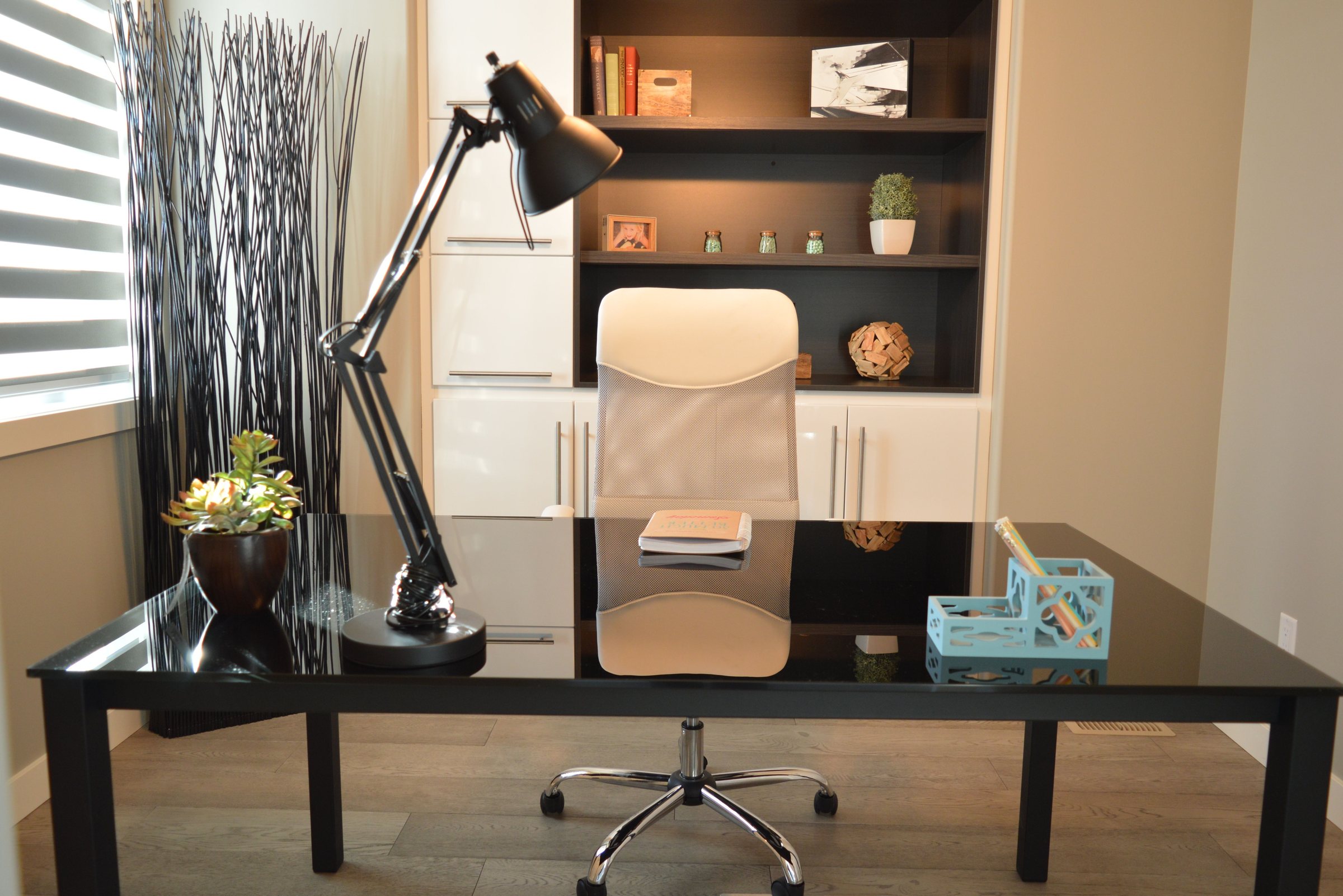 Bright home office with black glass desk and white chair in a Bieldside home