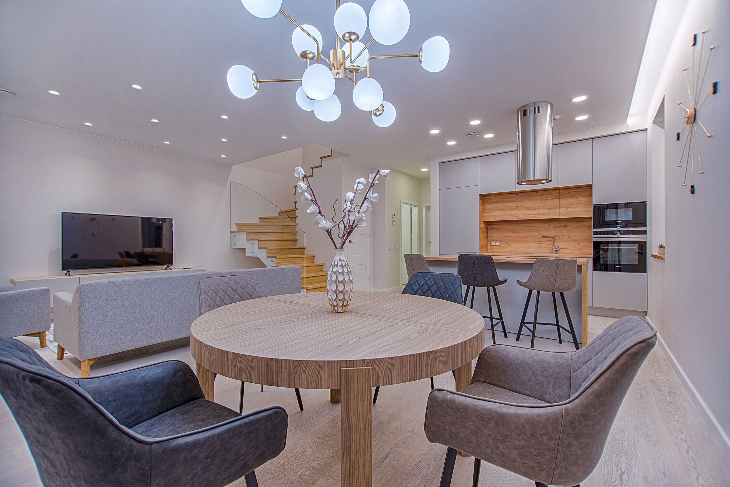 Open-plan dining, living and kitchen with glass staircase in a Cults family home