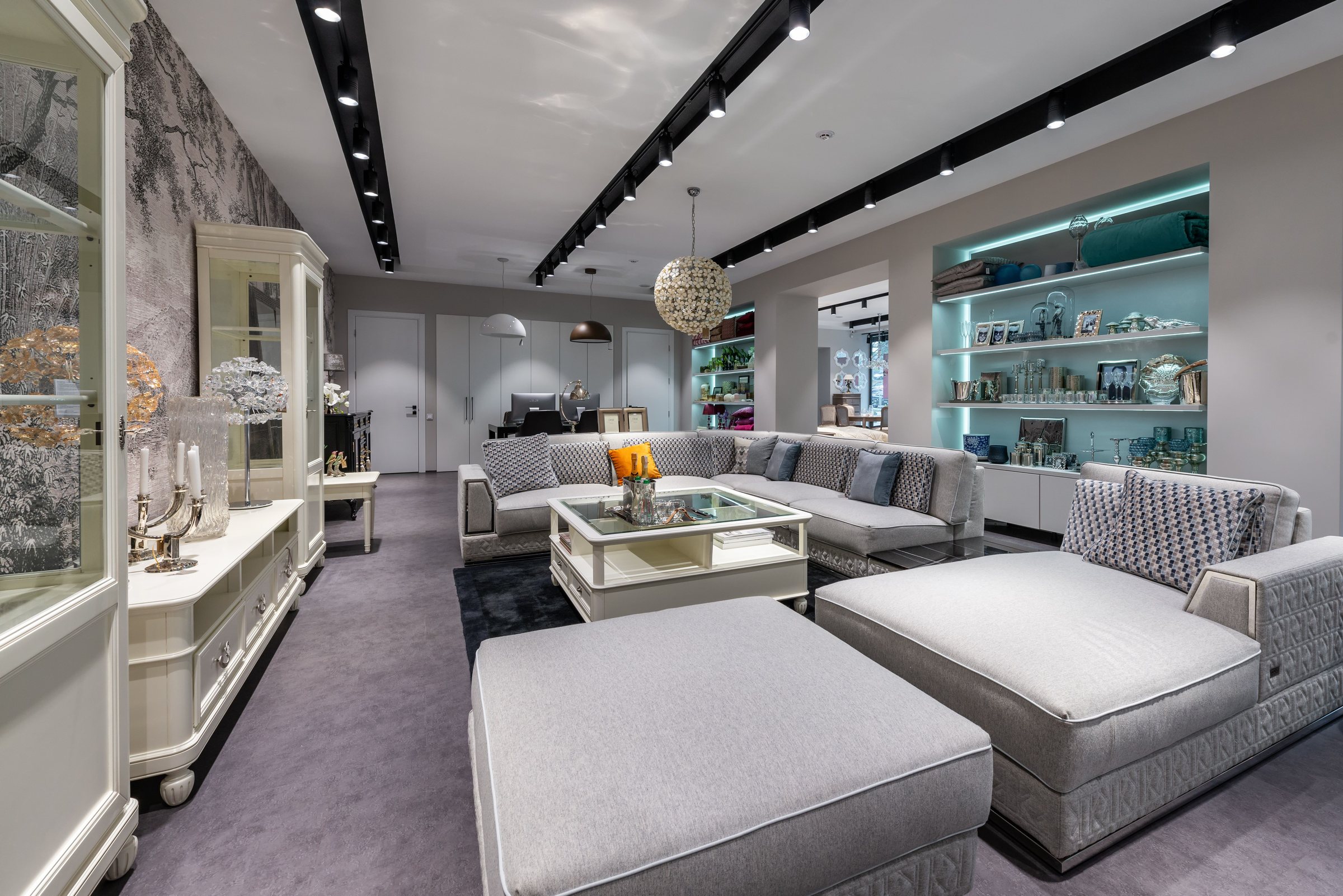 Luxury living room with grey sectional and teal lit shelves in a Milltimber home